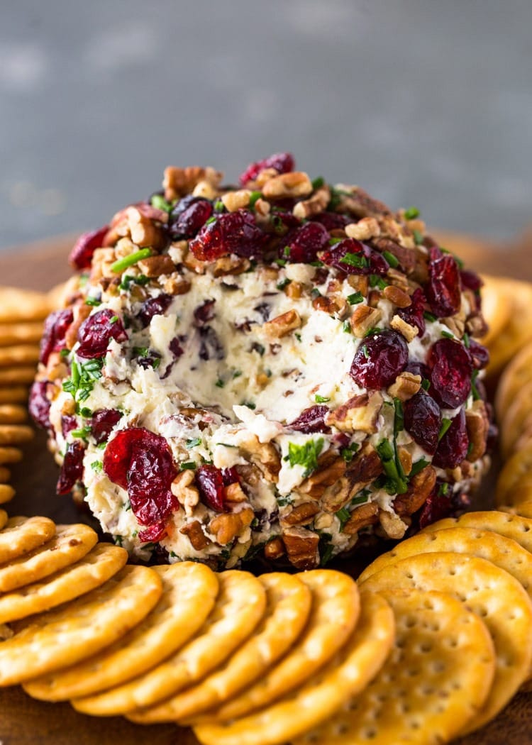 Cranberry pecan chive and garlic loaded cheese ball surrounded with crackers. 