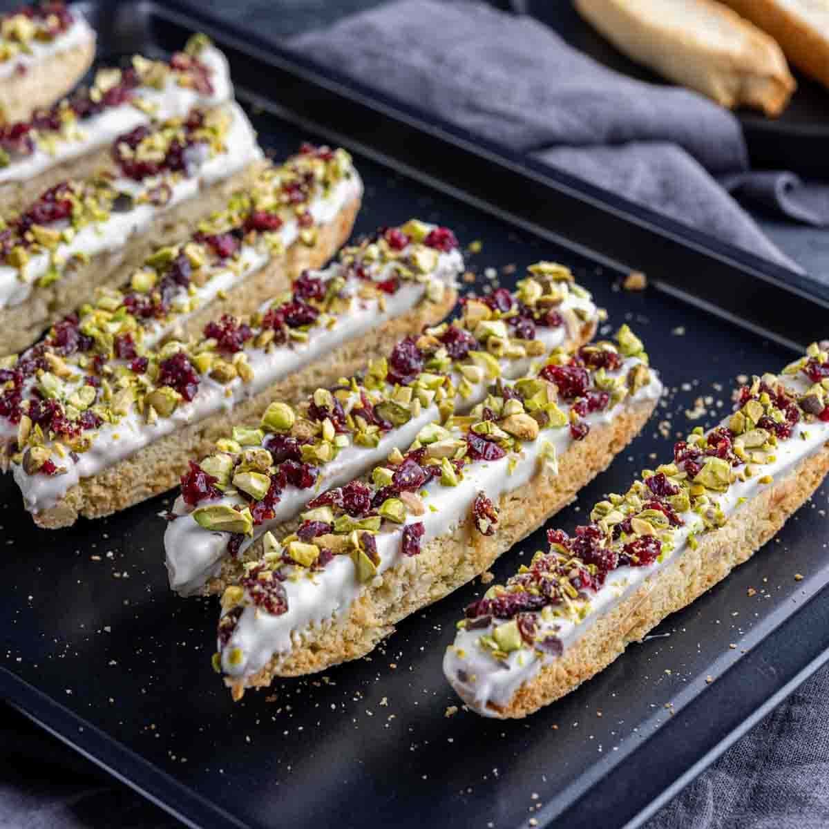 Biscotti topped with chopped pistachio and cranberries. 