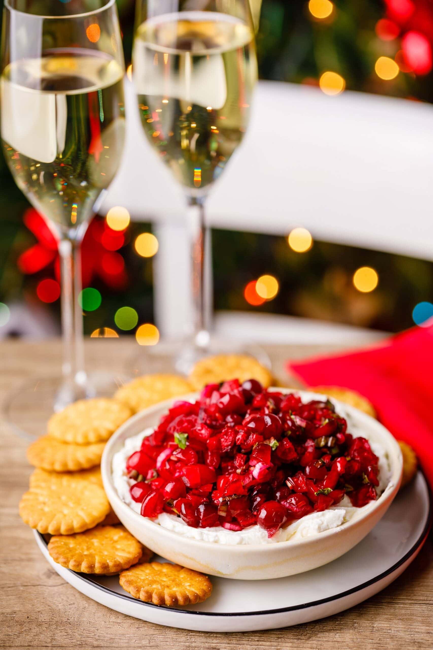 Cranberry jalapeno dip served with cracker and two glasses of wine. 