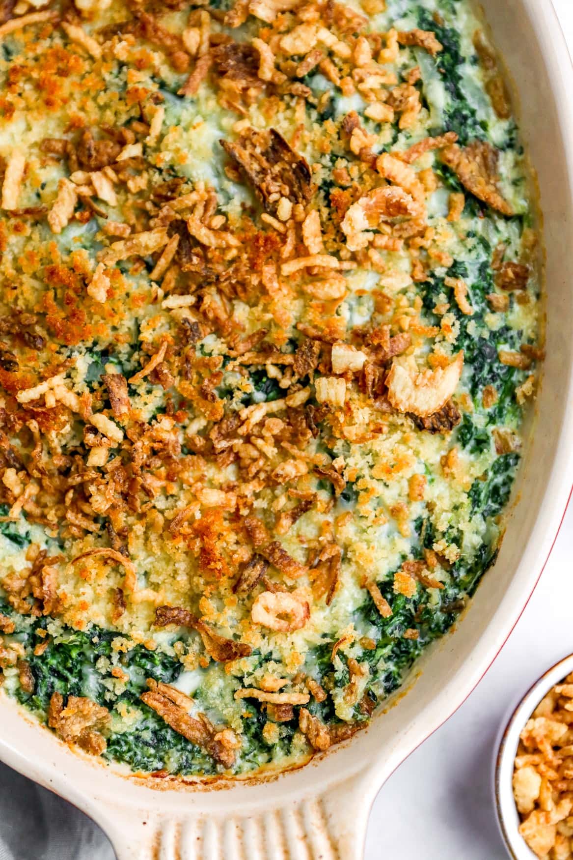 Creamed spinach gratin with crispy onions on a casserole dish. 