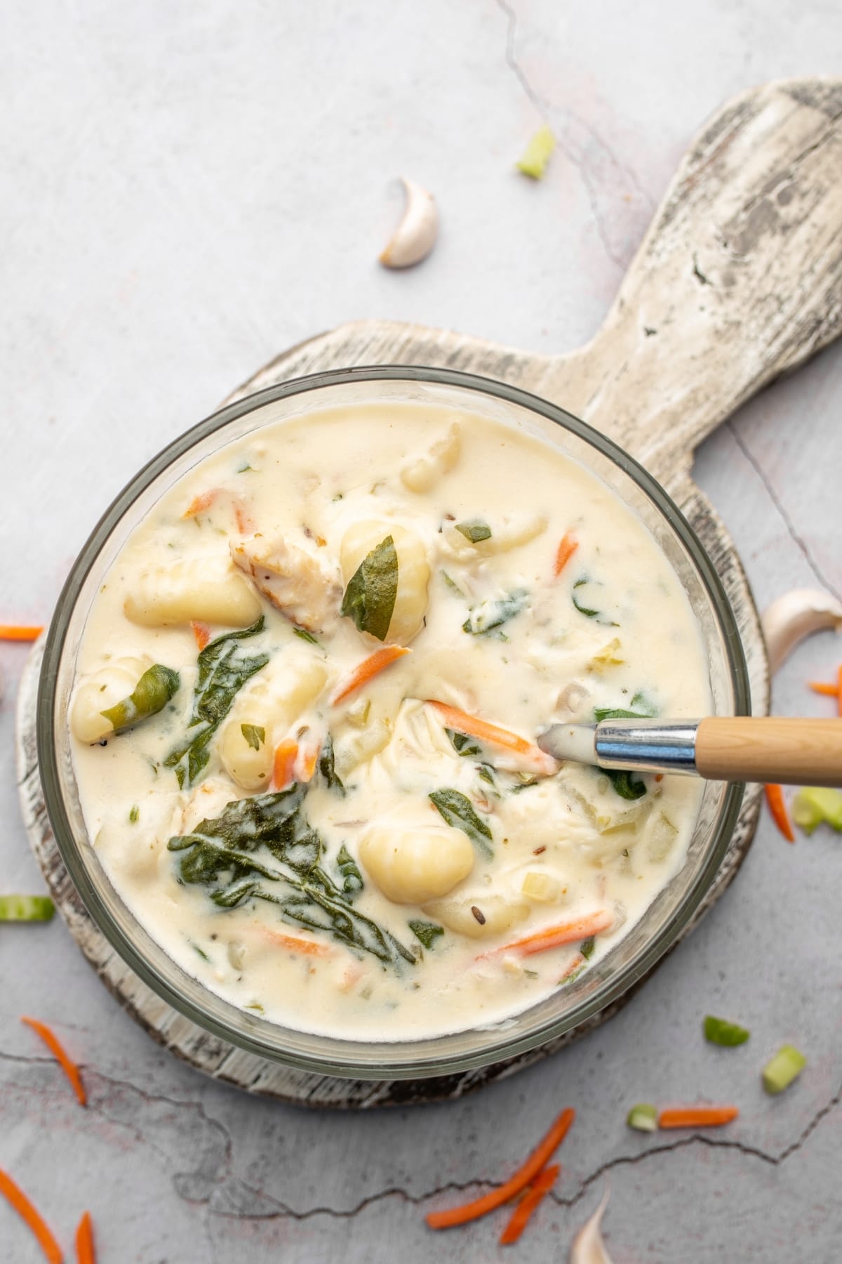 Hearty and Comforting Chicken and Gnocchi Soup with Baby spinach and Carrots in a Bowl with a Spoon