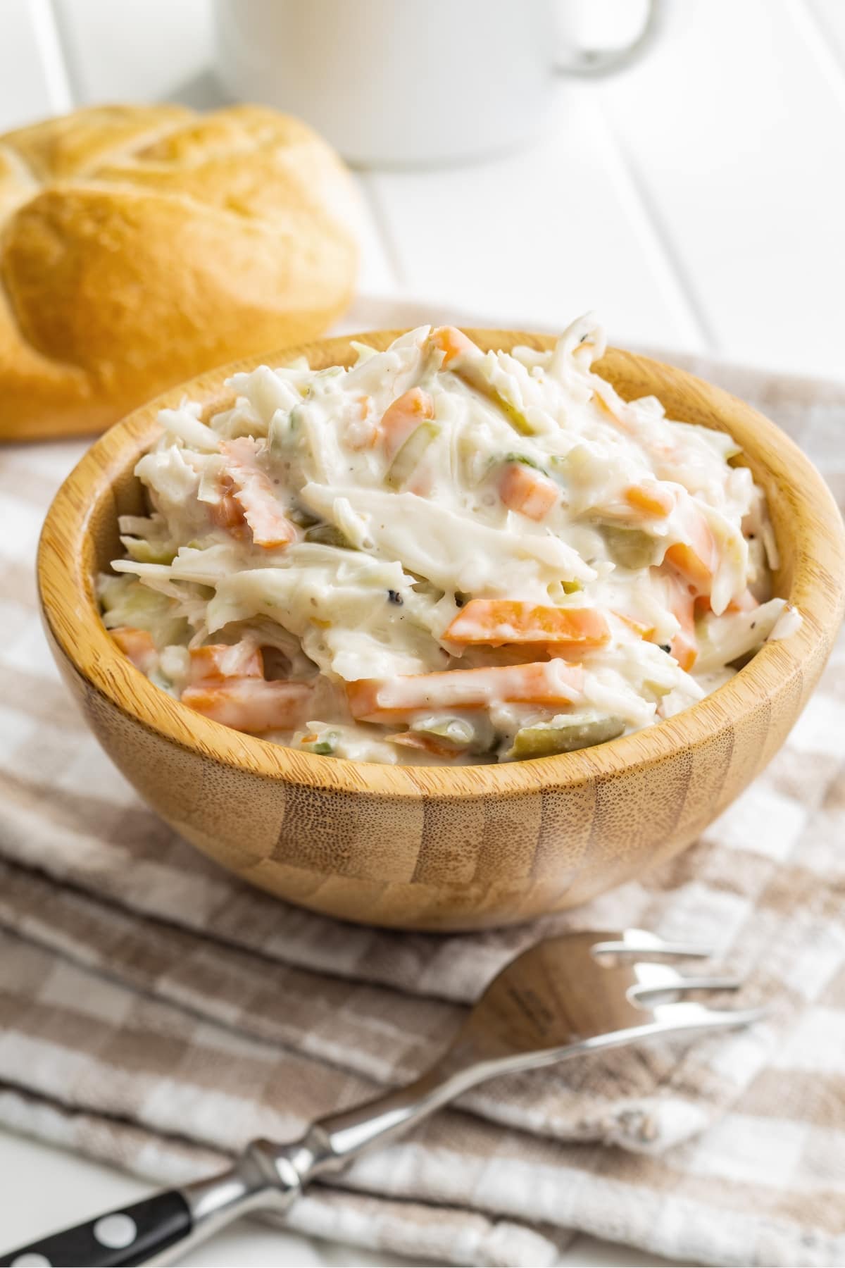 Creamy coleslaw served in wooden bowl.