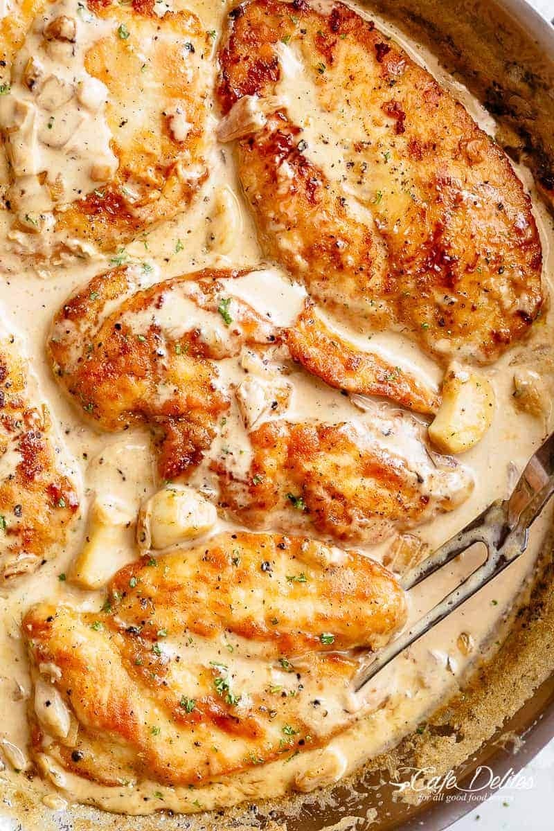 Garlic breast soaked in creamy sauce served on a pan. 