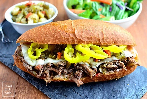 Crockpot Italian Beef Sandwiches with bowls of vegetables on the side