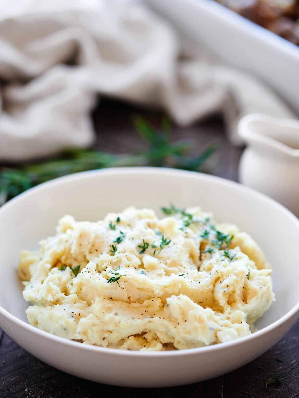 A serving of creamy mashed potato on a white bowl.