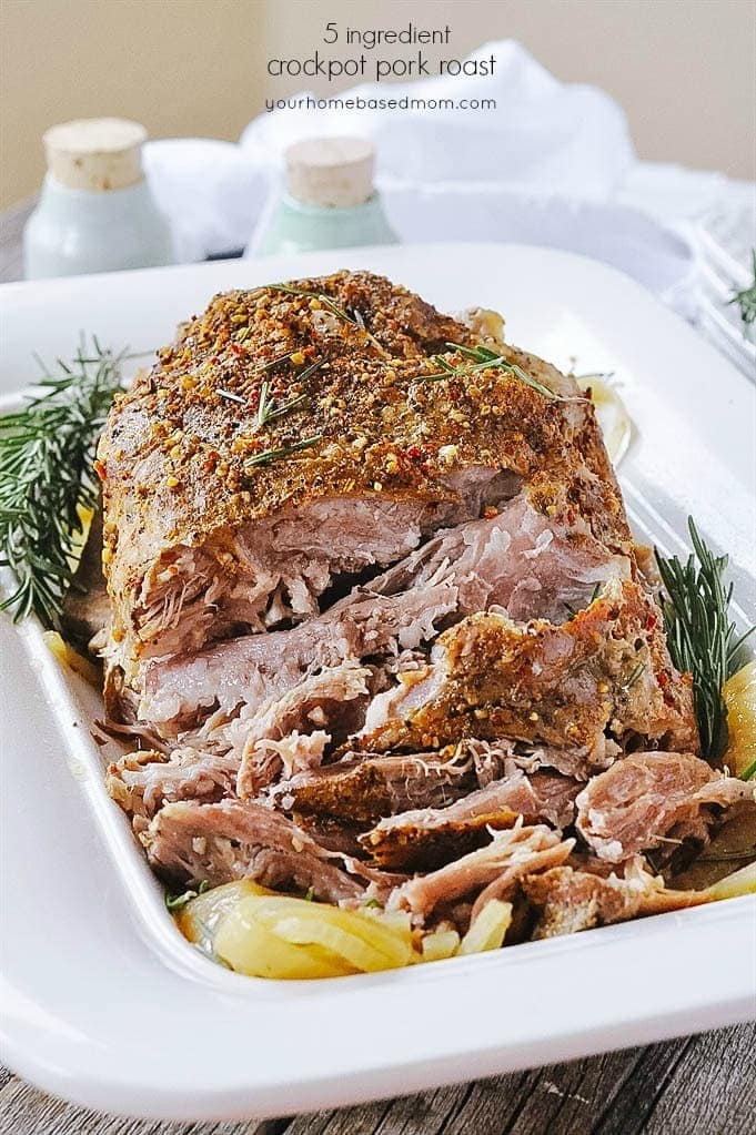 Roast pork pulled apart served with broth garnished with herbs and rosemary. 
