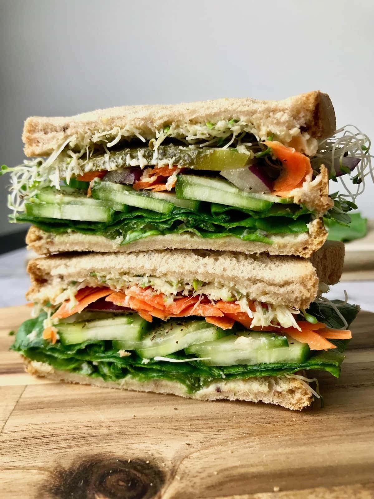 Sandwich with 
thin cucumber slices, romaine lettuce, pickle slices, shredded carrot, alfalfa sprouts, and thinly sliced red onion filling. 