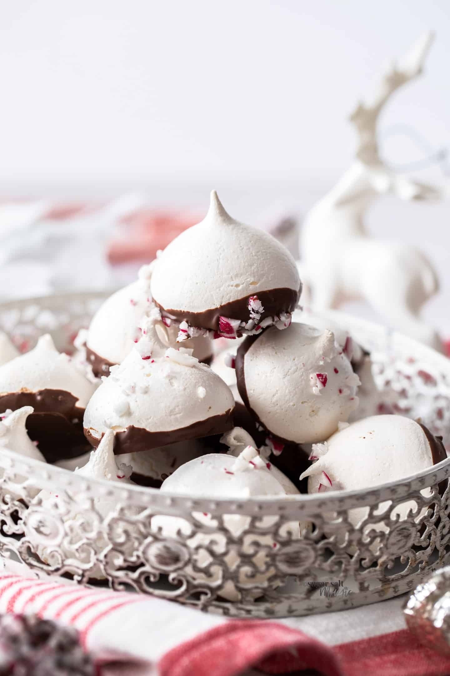 Bunch of peppermint meringues half dipped with chocolate and chopped candy sugars. 