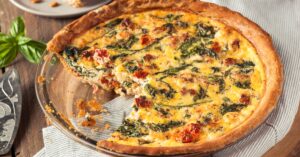 A delicious spinach and cheese quiche placed on a wooden table