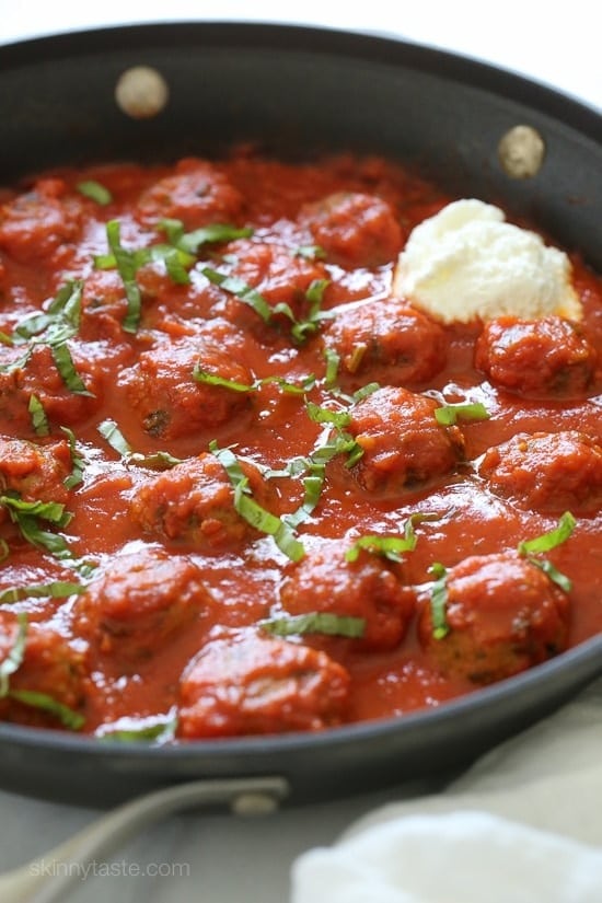 Eggplant meatballs in a pan soaked in tomato sauce. 