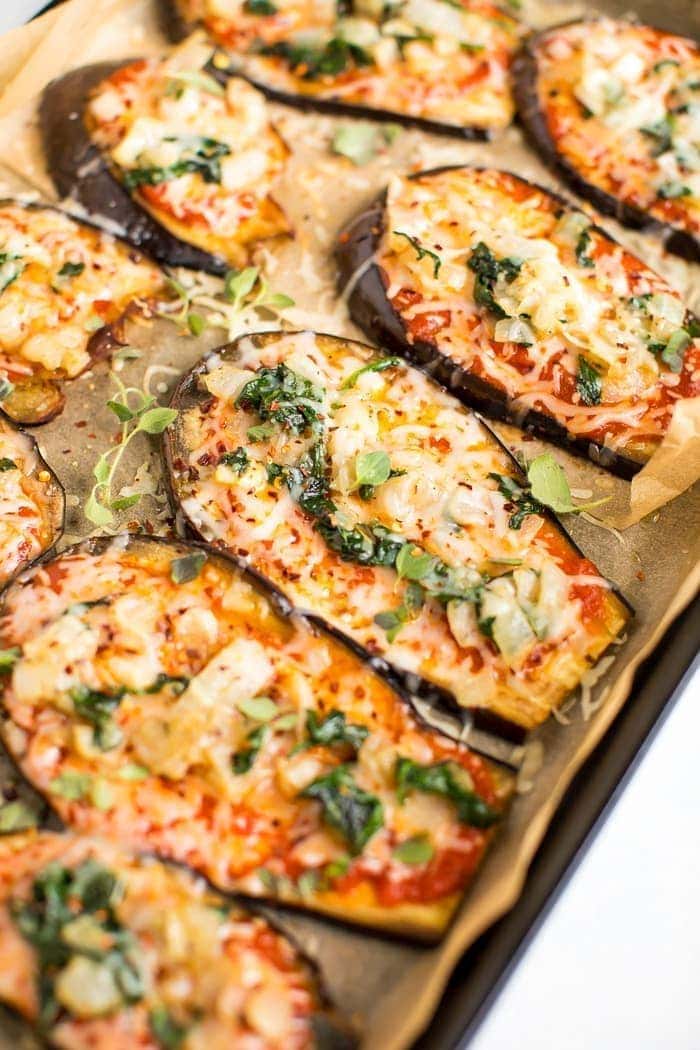 Sliced eggplant topped with melted cheese and spinach. 