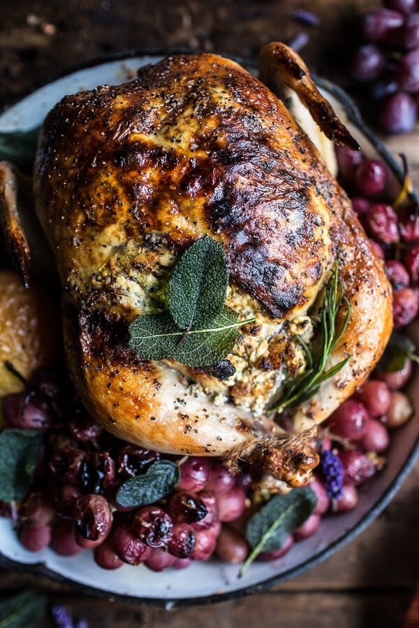 Top view of roasted chicken served with walnut, goat cheese and grapes. 