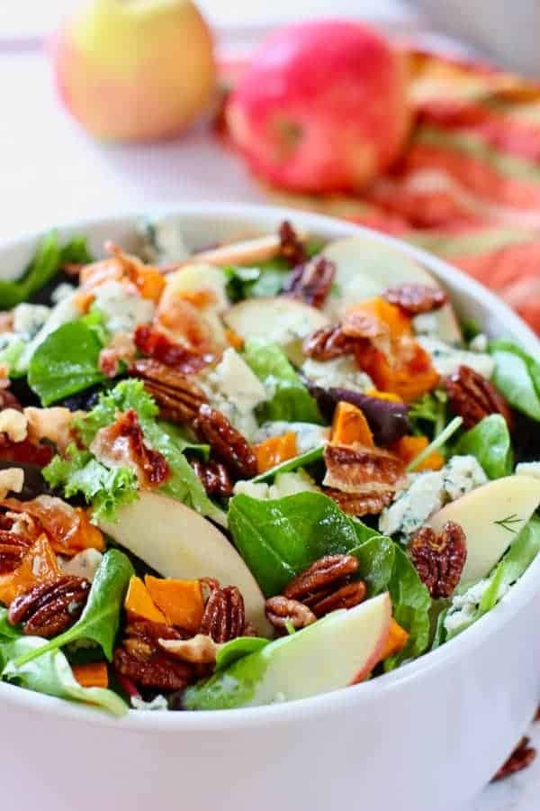 Autumn salad with roasted sweet potatoes and maple cider vinaigrette in a bowl.
