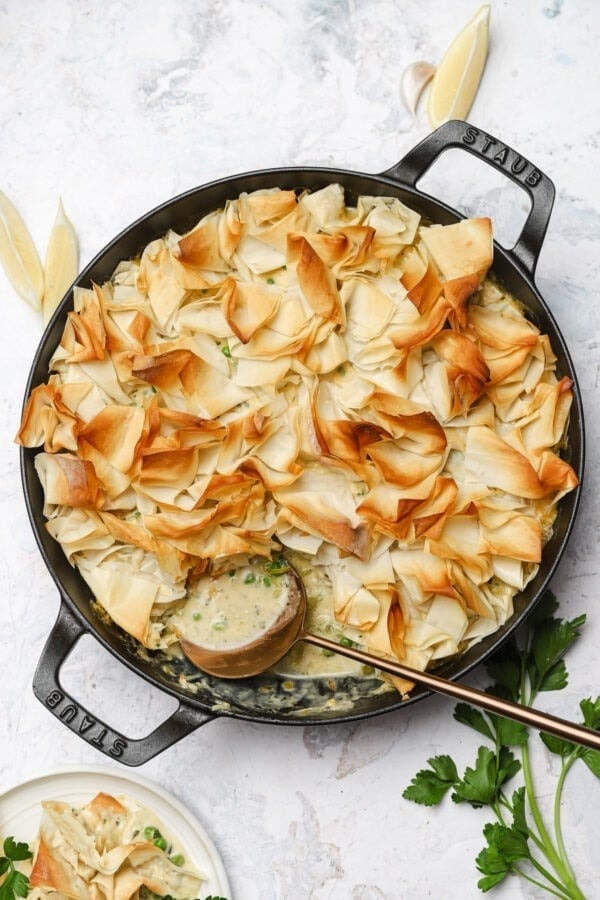 Fish pie topped with puff pastry cooked on a pan. 