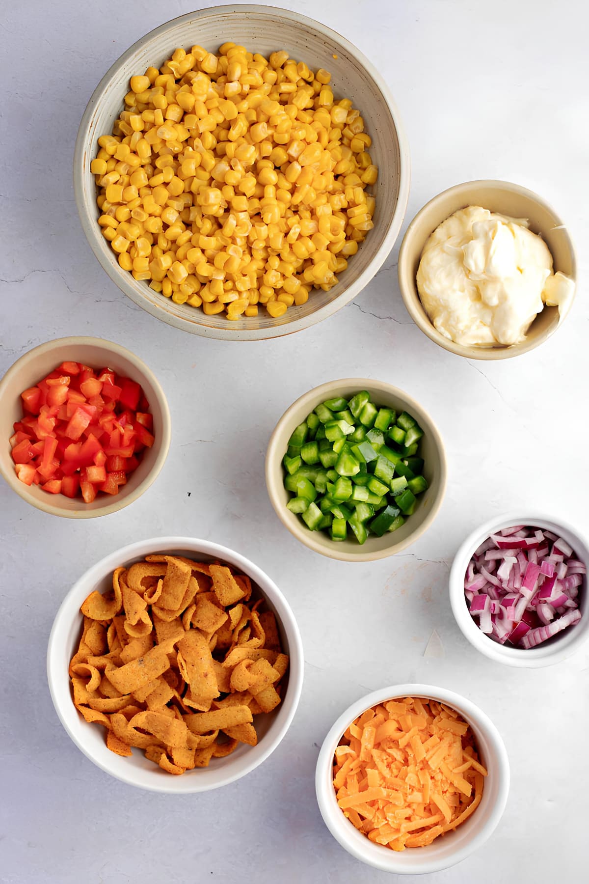 Colorful bowls of various frito corn ingredients