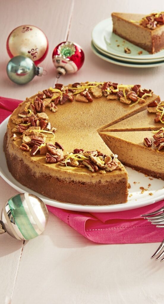 Sliced whole gingerbread cheesecake topped with crushed pecan and graham crust.
