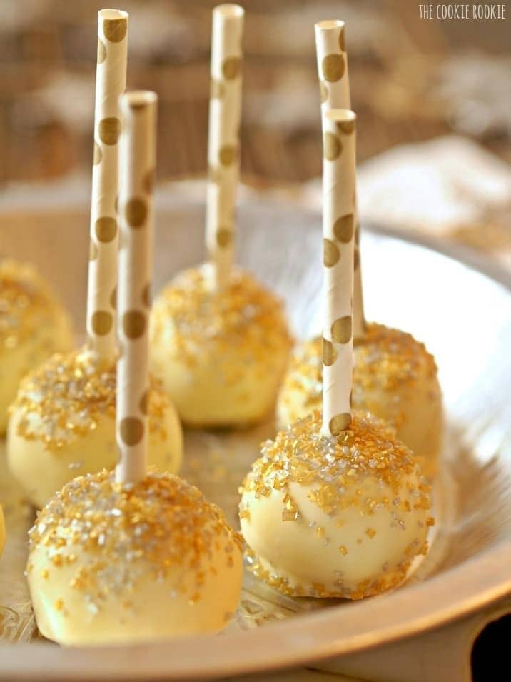 Cake pops on stick covered with gold glitters and sprinkles. 