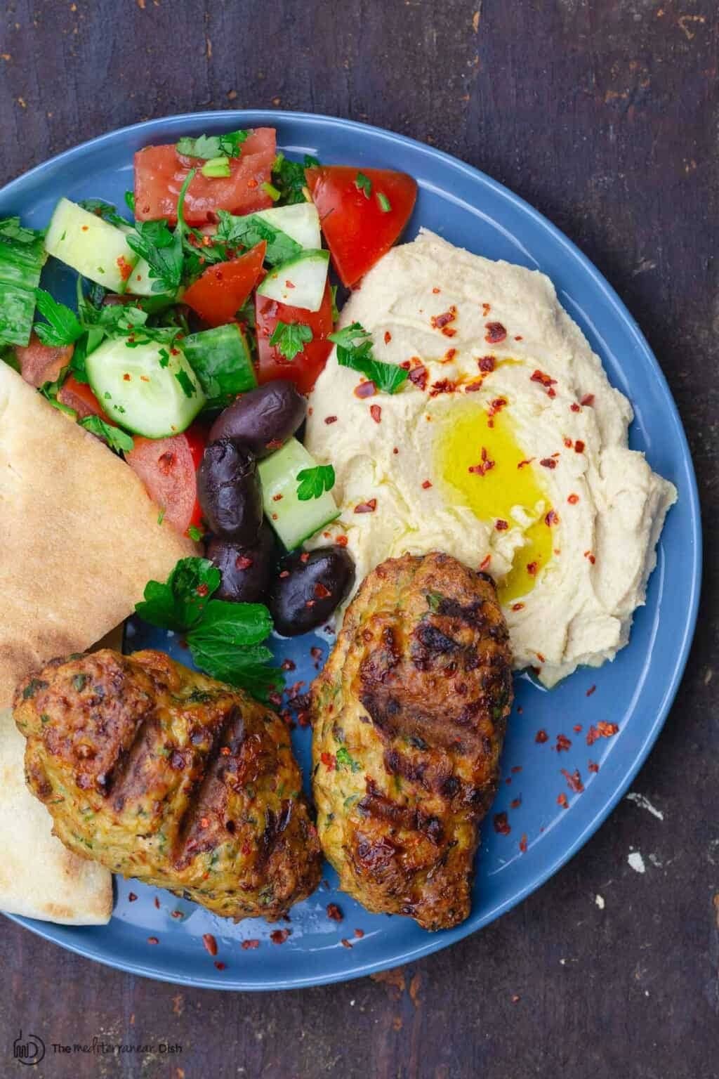 Grilled chicken kofta served with hummus, vegetable salad and feta bread.