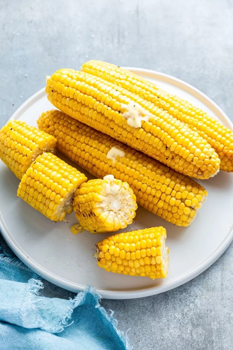 Grilled corn with butter on plate. 