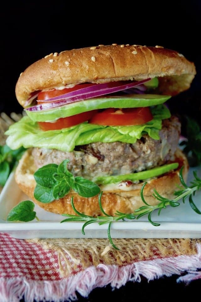 Delicious Greek Burger with Olives, Rosemary, and Feta in the Patty, Served on a Bun with Lettuce, Tomatoes, and Red Onions