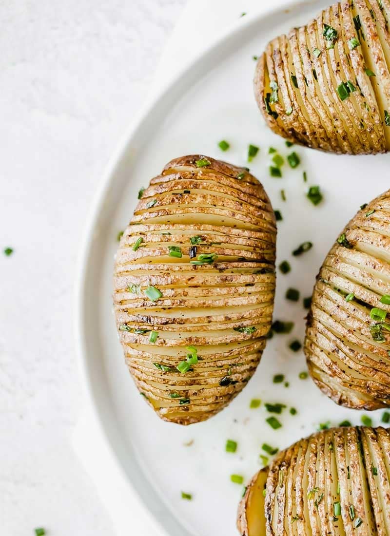 Sliced Hasselback potatoes garnished with chopped green onions. 