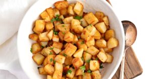 Hearty and Tasty Home Fries in a Bowl on a Wooden Board
