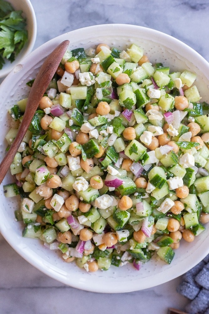 Bowl of cucumber salad with feta cheese and chickpeas. 