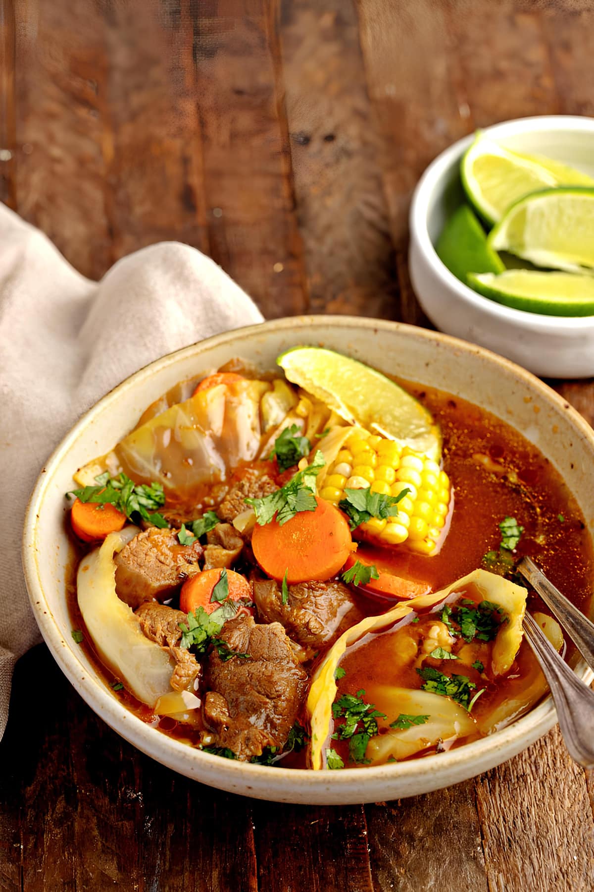 A warm bowl of mexican beef soup or caldo de Res with corn and vegetables