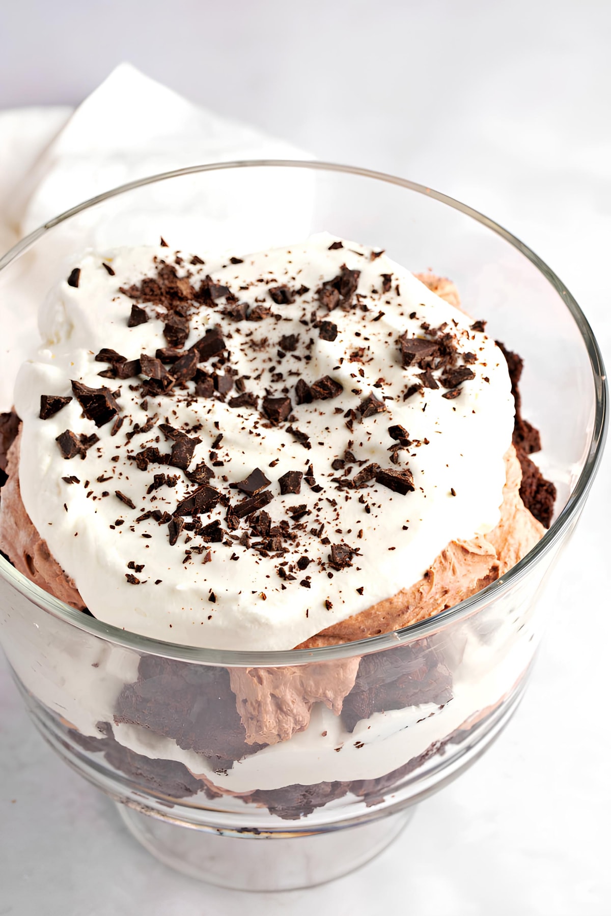Chocolate trifle in a glass bowl topped with whipped cream and brownies, a delightful treat