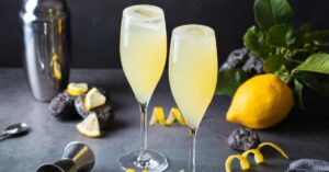 Two glasses of french 75 cocktail with lemons