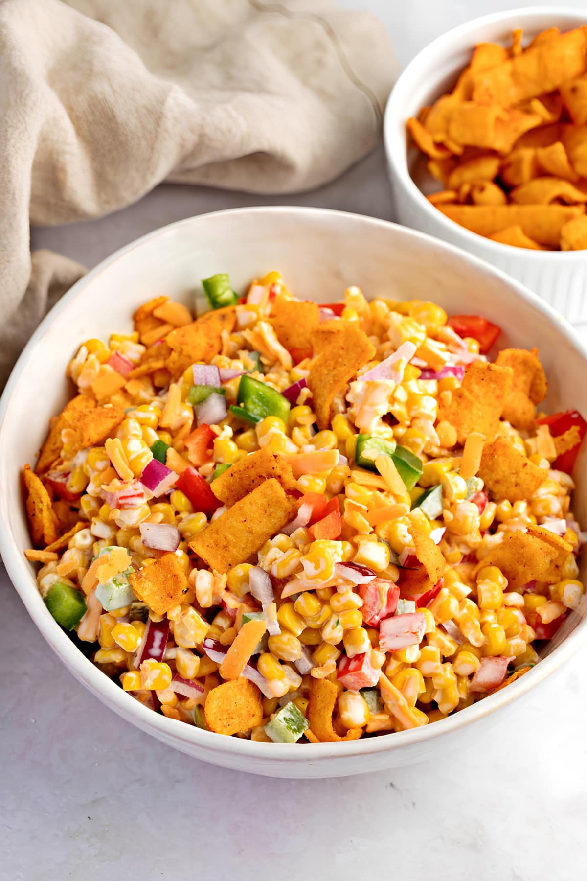 Bowl of Creamy Frito Corn Salad with Peppers and Onions