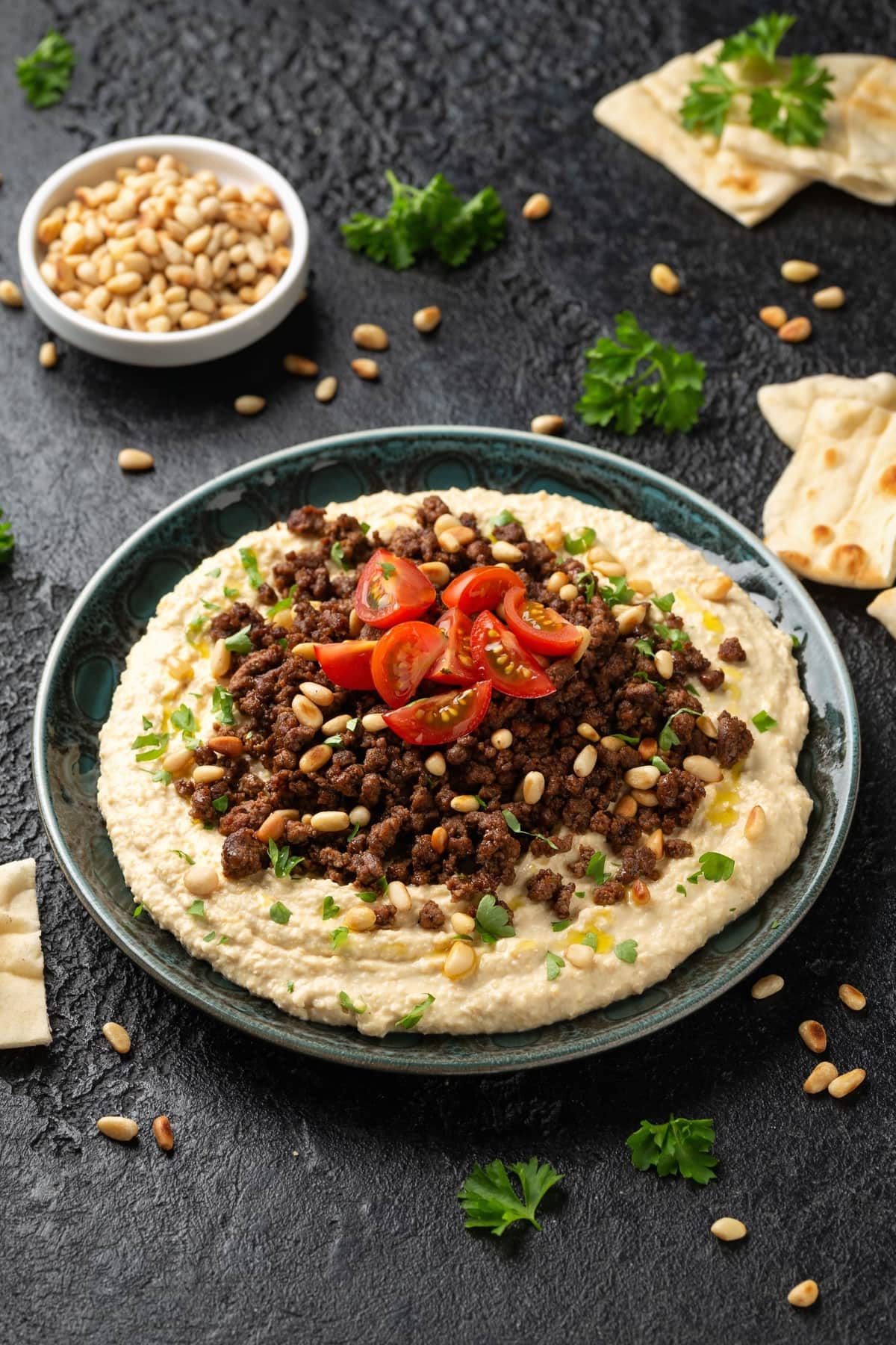 17 Easy Mediterranean Ground Beef Recipes featuring A savory dish of hummus topped with ground beef and veggies, set against a dark backdrop