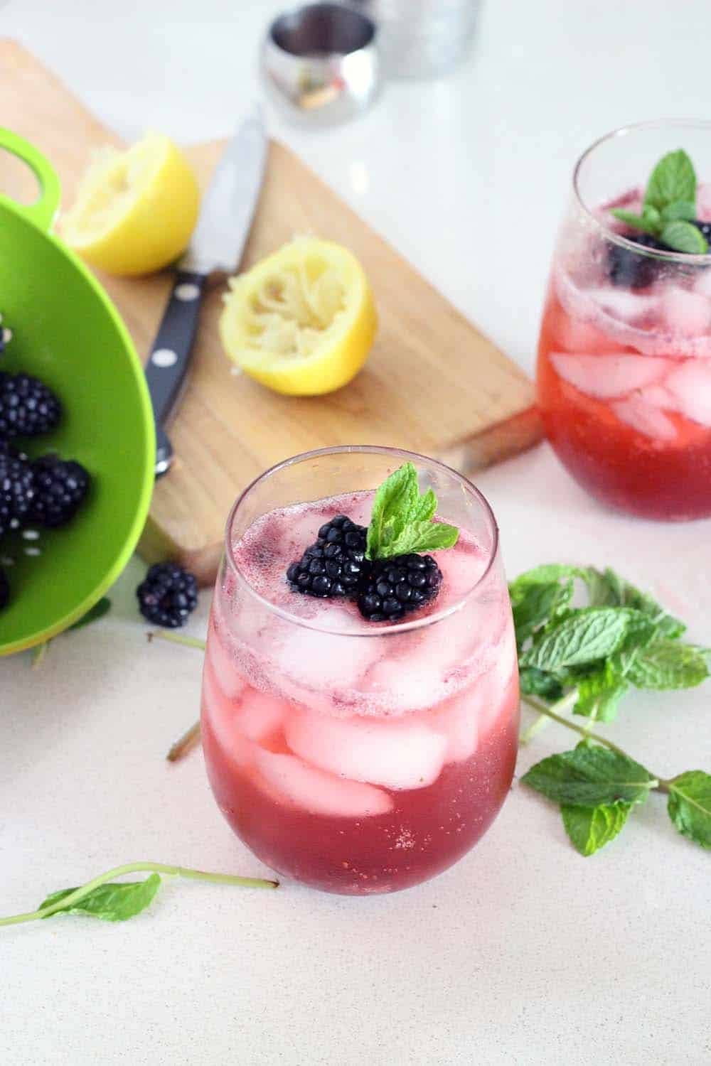 Iced blackberry mocktails garnished with fresh blackberries and mint. 