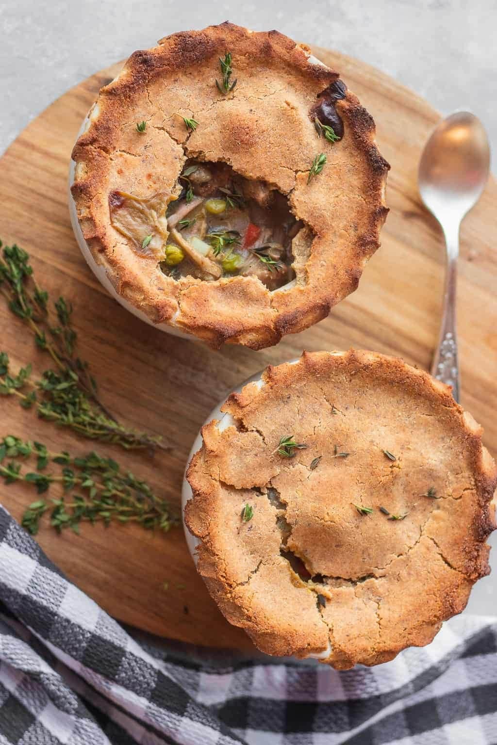 Two small pot pies on a wooden tray.
