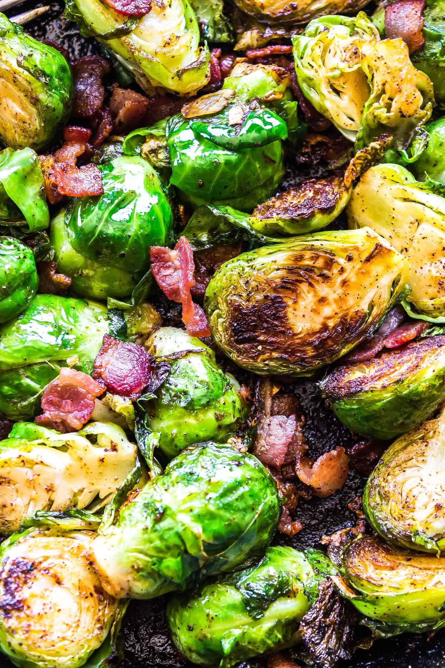 Roasted brussels sprouts with bacon on a pan.