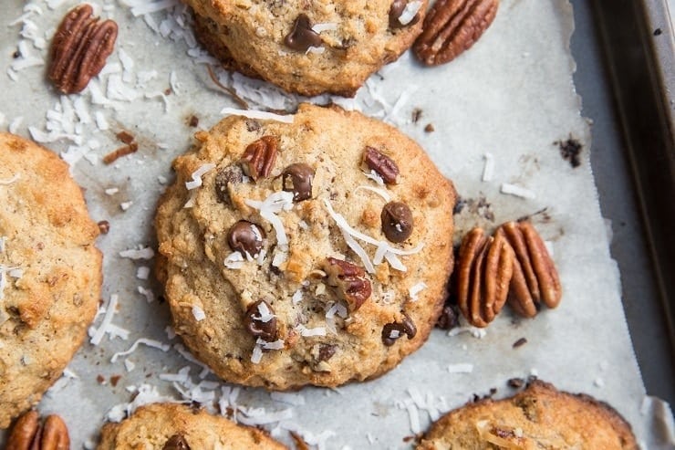 Cookies with chocolate, coconut, pecans, cinnamon, sprinkled with sea salt on a sheet pan. 