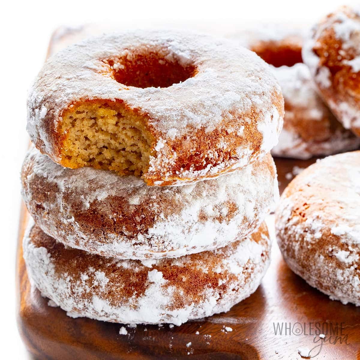 Stack of donuts coated with powdered sugar.