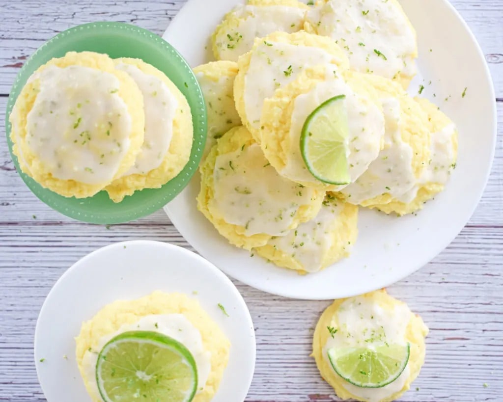 Lime cookies on plate topped with cream cheese and lemon zest. 