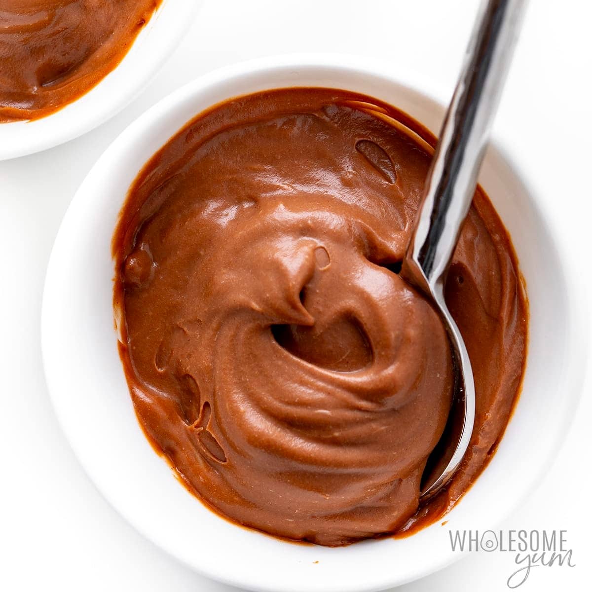 Spoon mixing chocolate pudding in a bowl. 