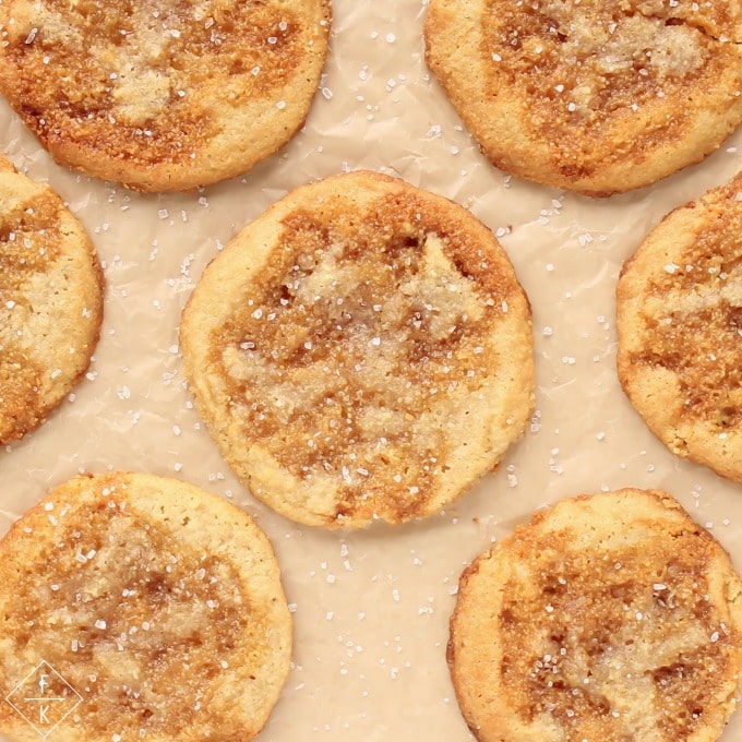 Caramel sugar cookies flat lay on a parchment paper sprinkles with salt.