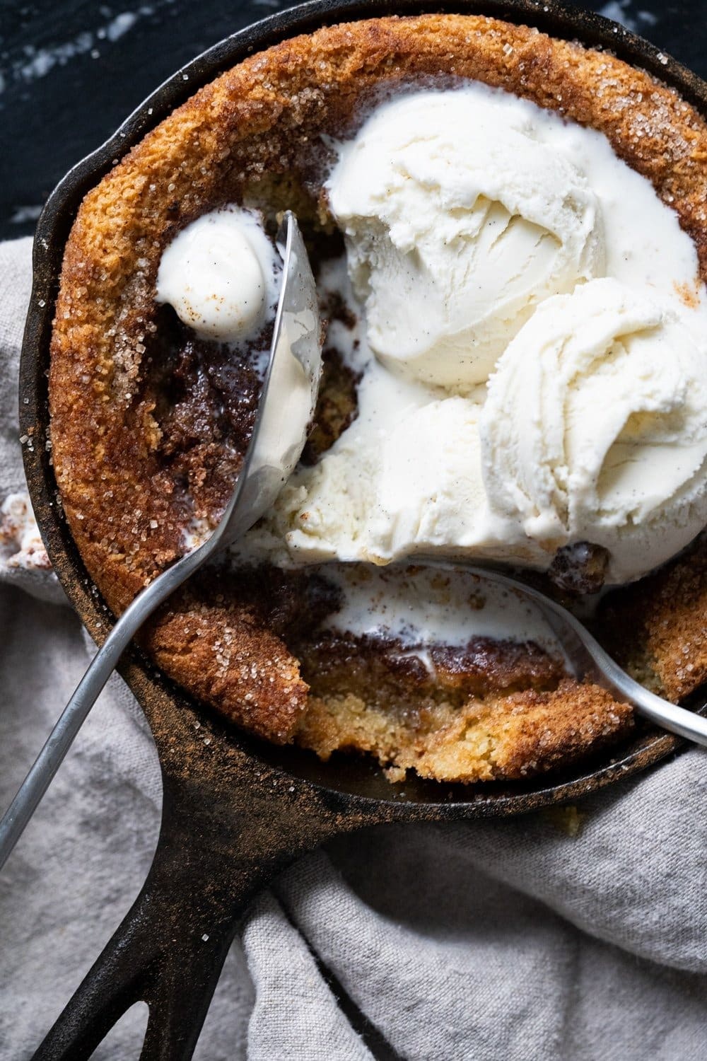 Snickerdoodle cookie cooked in a skillet topped with cream. 