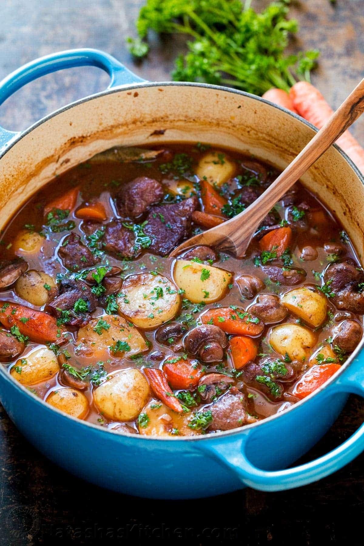 Lamb stew with potatoes, carrots and mushroom in a blue pot.
