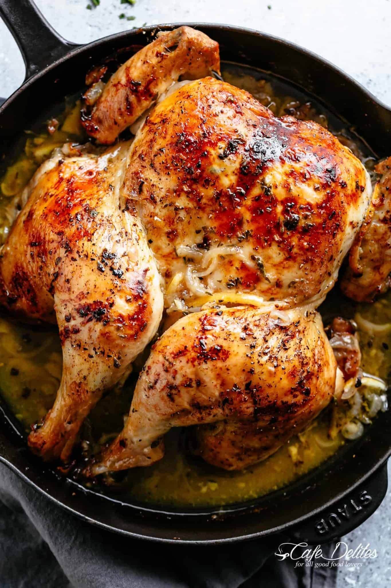 Roasted chicken in skillet with lemon sauce.