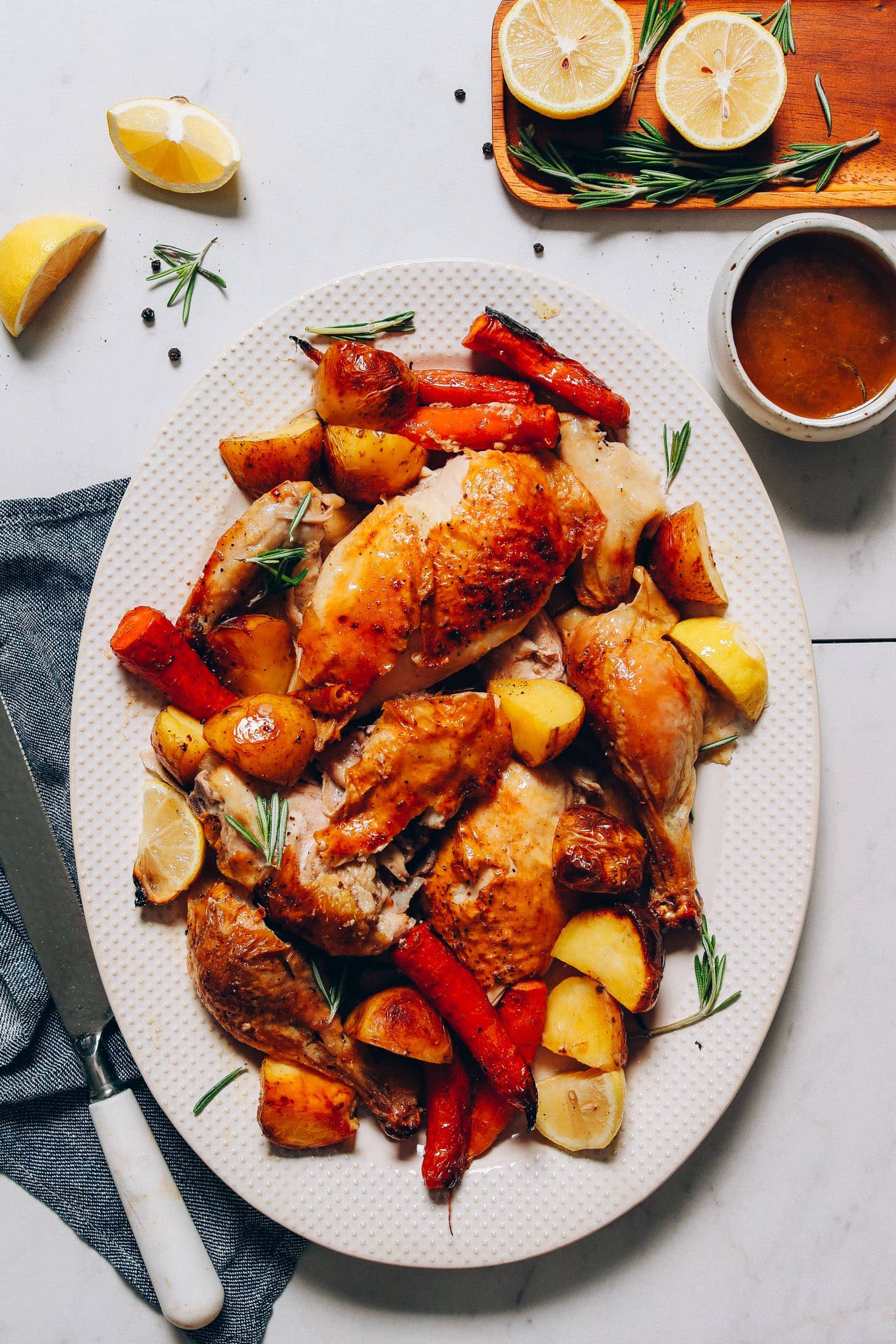 Sliced roasted chicken served with potatoes and roasted veggies on plate.
