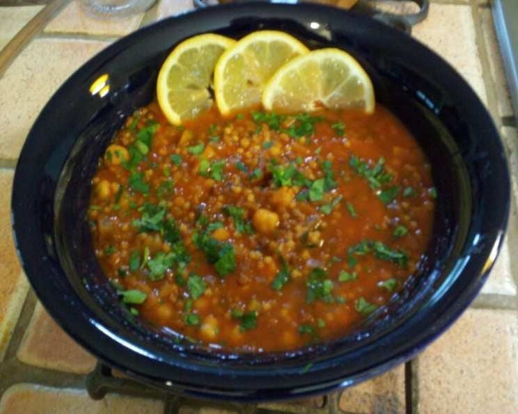 Lentil and Chickpea Soup on a slow cooker with slices of lemon