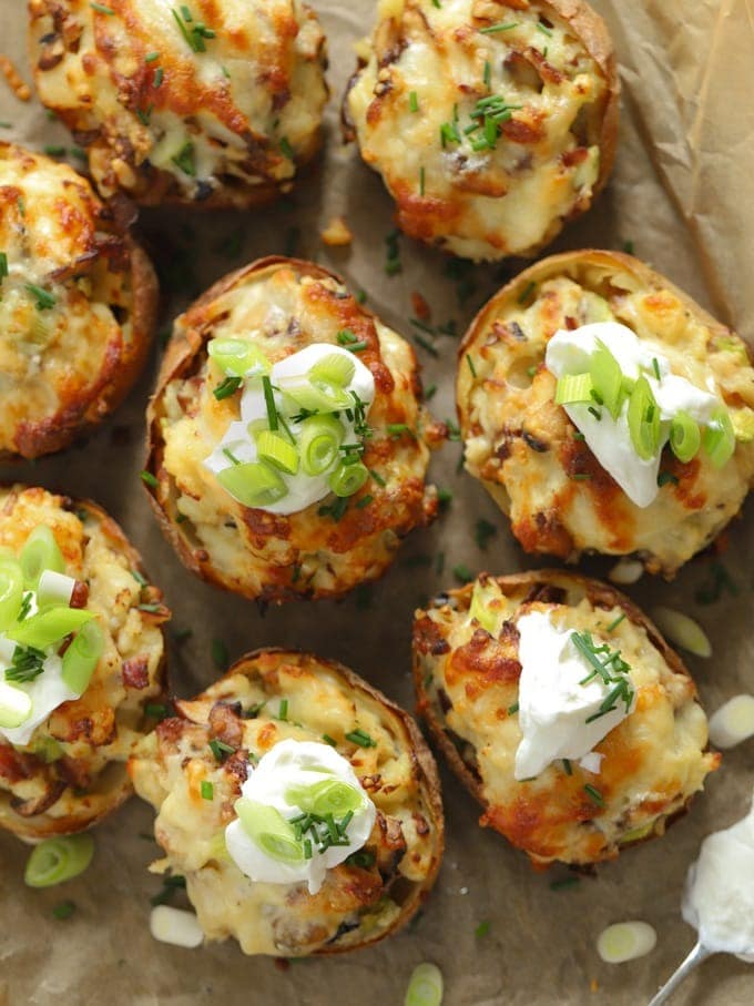 Potato skins stuffed with creamy filling topped with sour cream and chopped onion leaves.