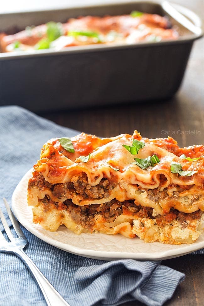 A slice serving of lasagna on plate. 