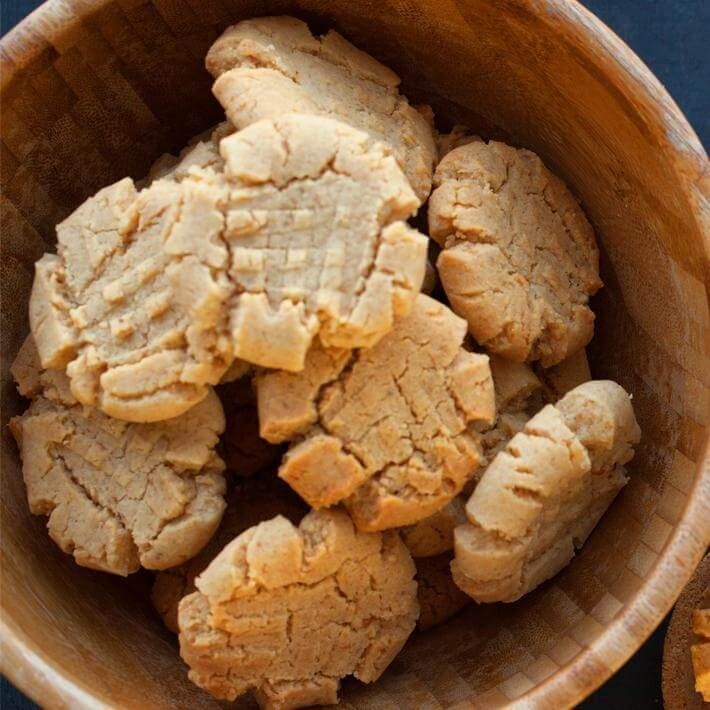 Almond cinnamon butter cookies on a wooden bowl.