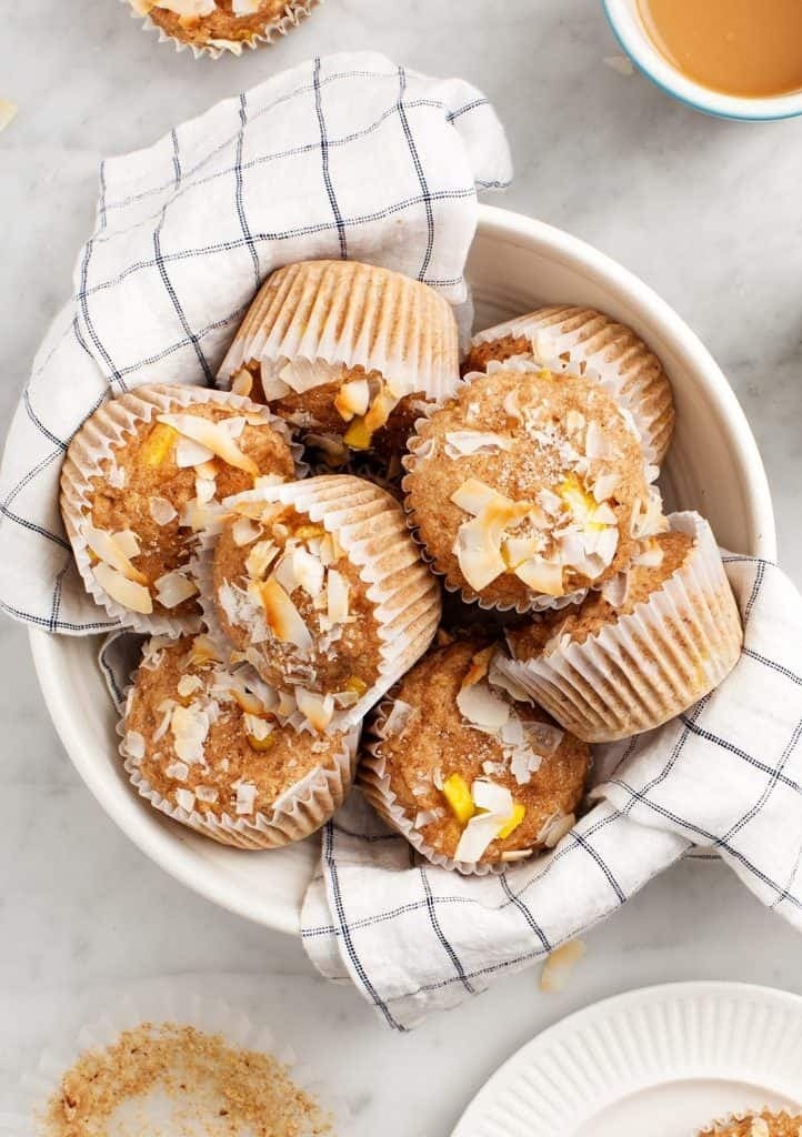 Bunch of mango muffins on a bowl with coconut shred on top. 