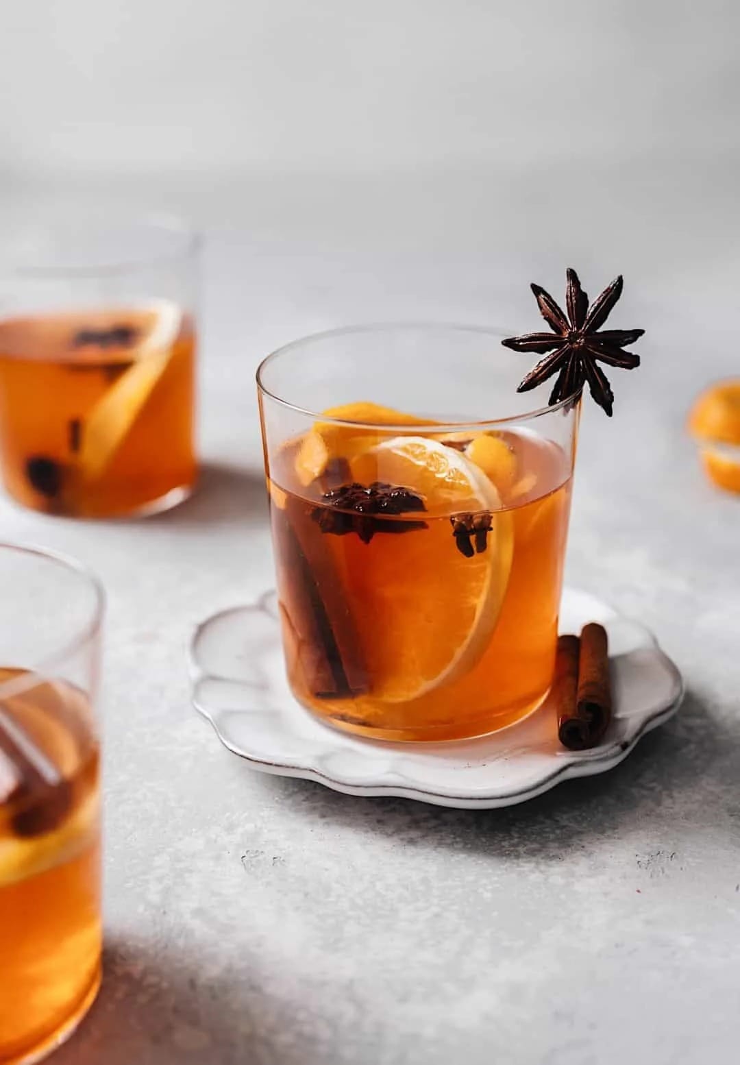 Mulled cocktail garnished with slices of lemon, star anise and cinnamon sticks. 
